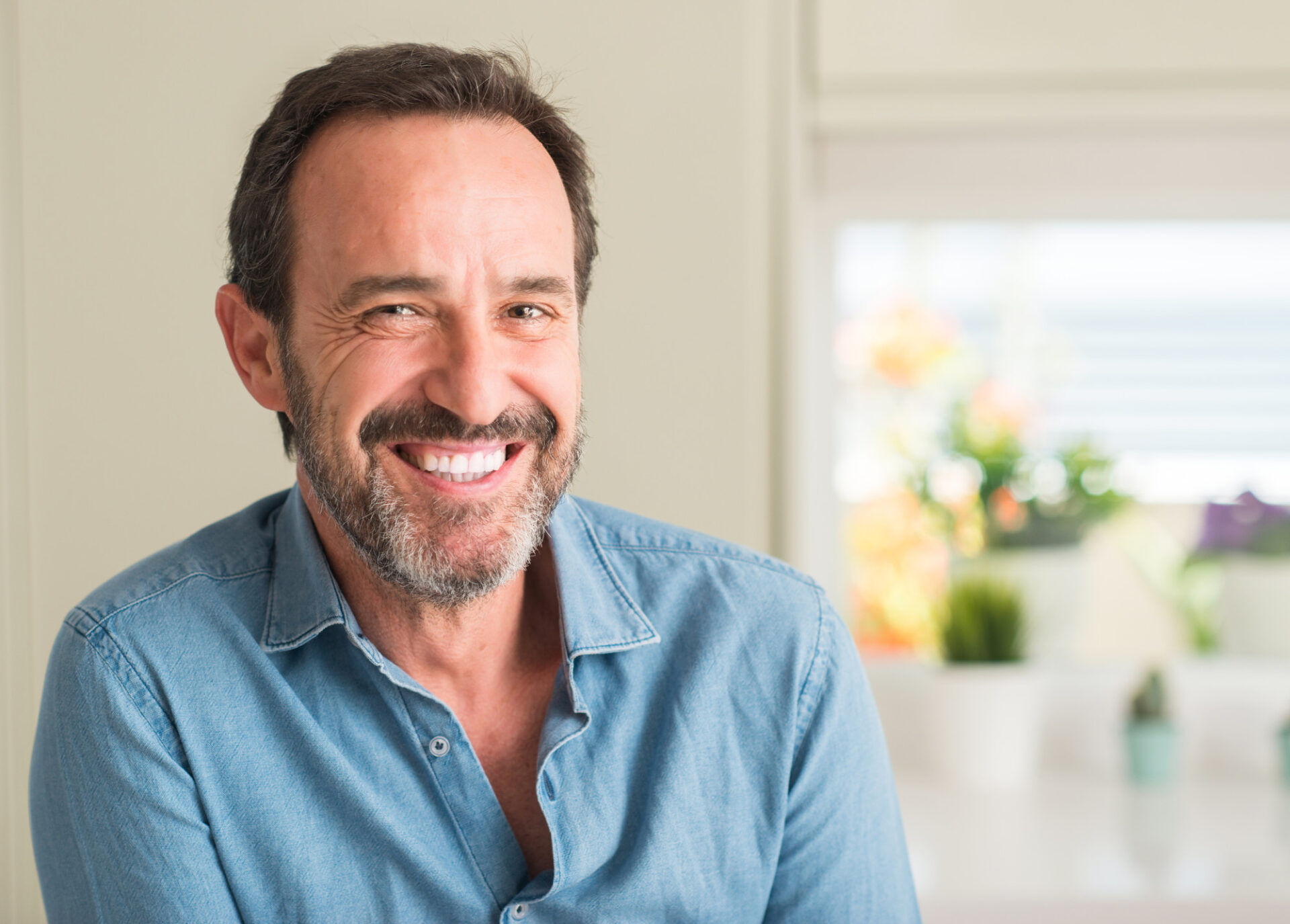 Handsome middle age man with a happy face standing and smiling with a confident smile showing teeth full mouth implant restoration, loose dentures